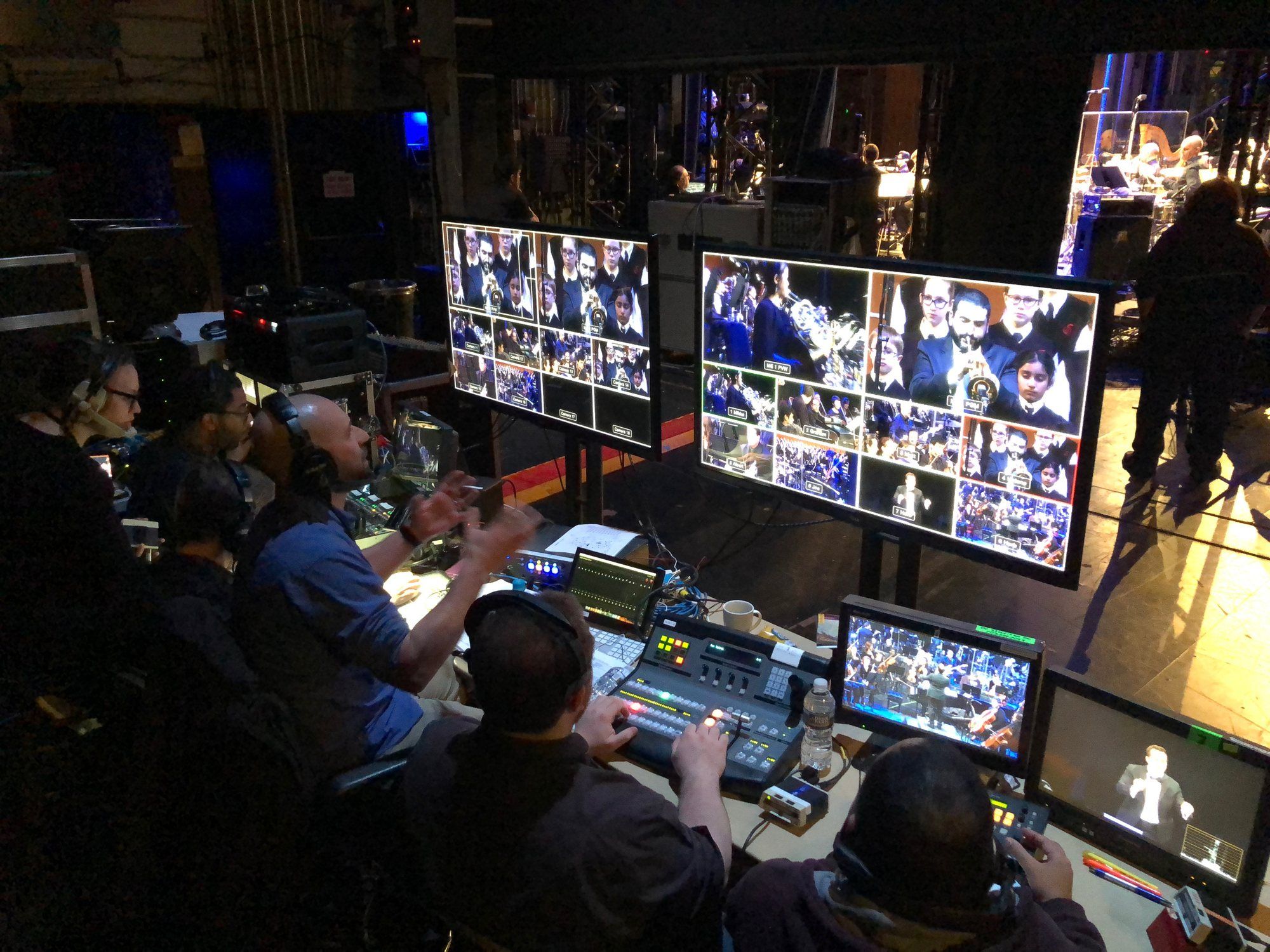 A live production team at video switchers and multiview monitors, streaming an orchestra concert.
